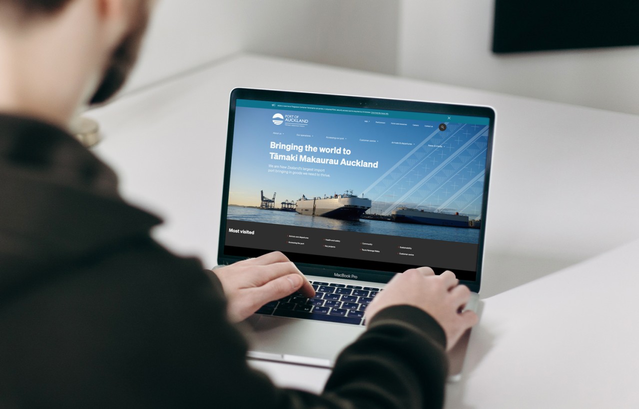 Man looking at a laptop with poal.co.nz on it